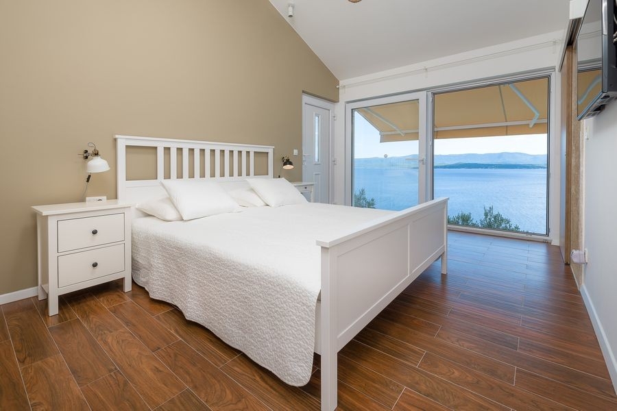 Camera da letto con letto matrimoniale e grandi finestre sul mare
