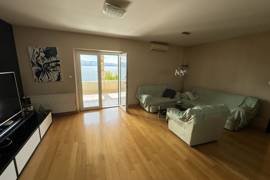 Soggiorno con pavimento in legno e accesso al balcone