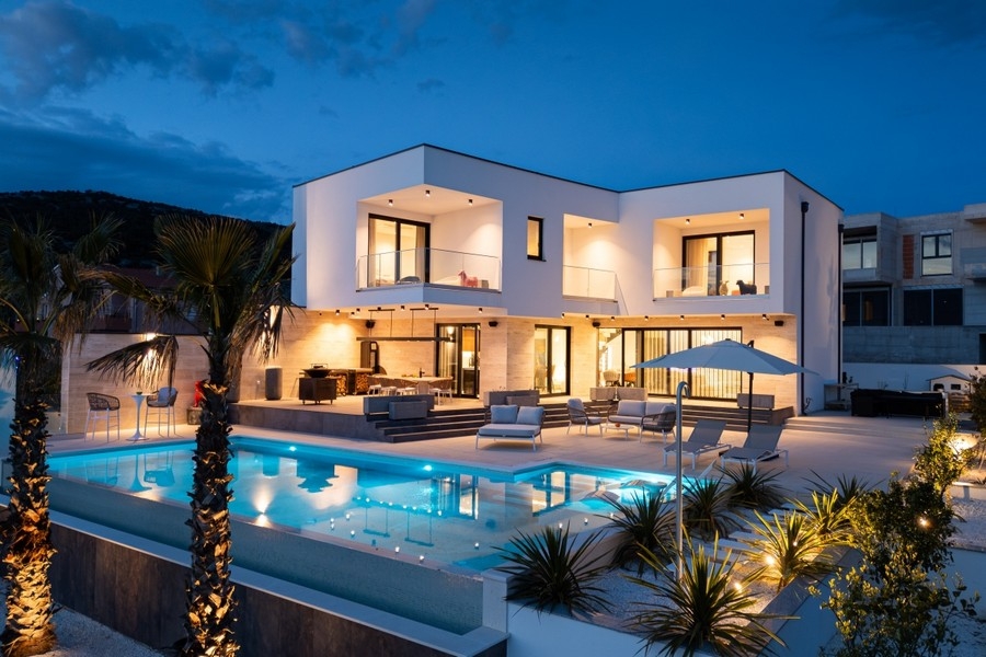 Villa di lusso illuminata con infinity pool al crepuscolo