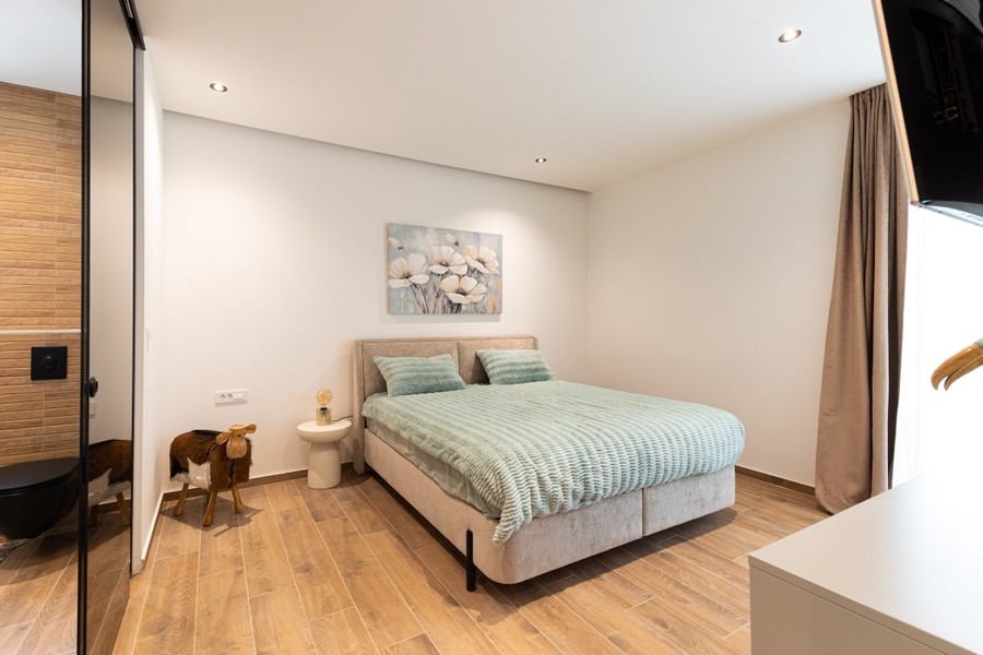 Camera da letto con letto matrimoniale e pavimento in legno