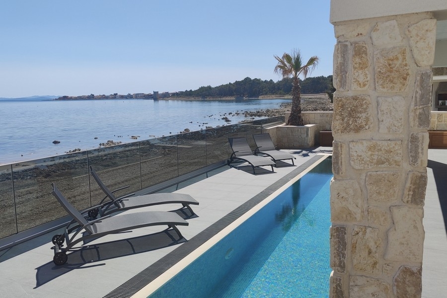 Lettini a bordo piscina con vista sul mare