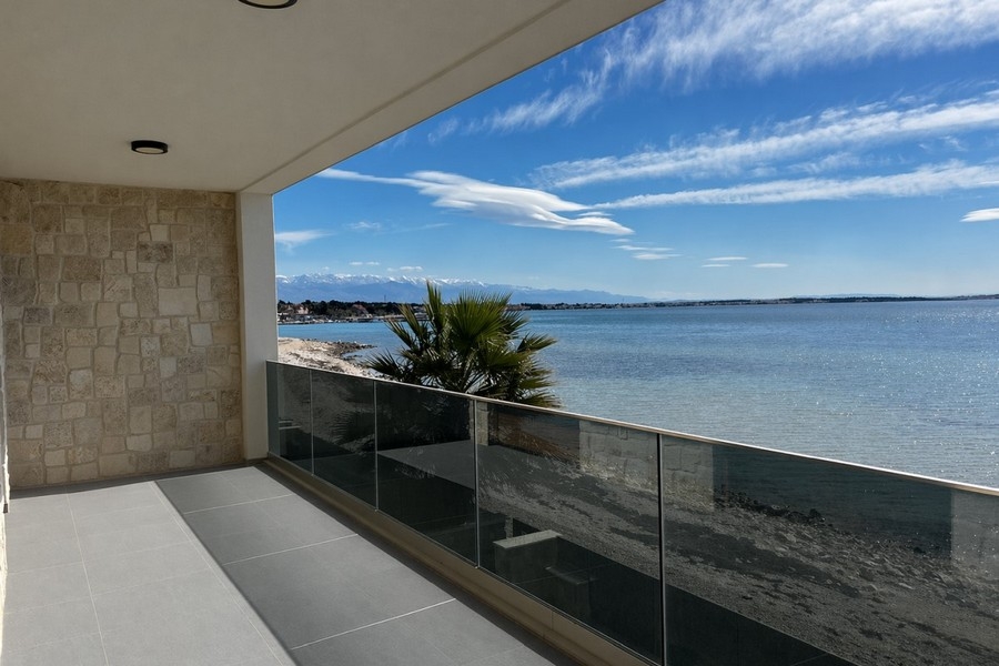 Terrazza coperta con parapetto in vetro e vista mare