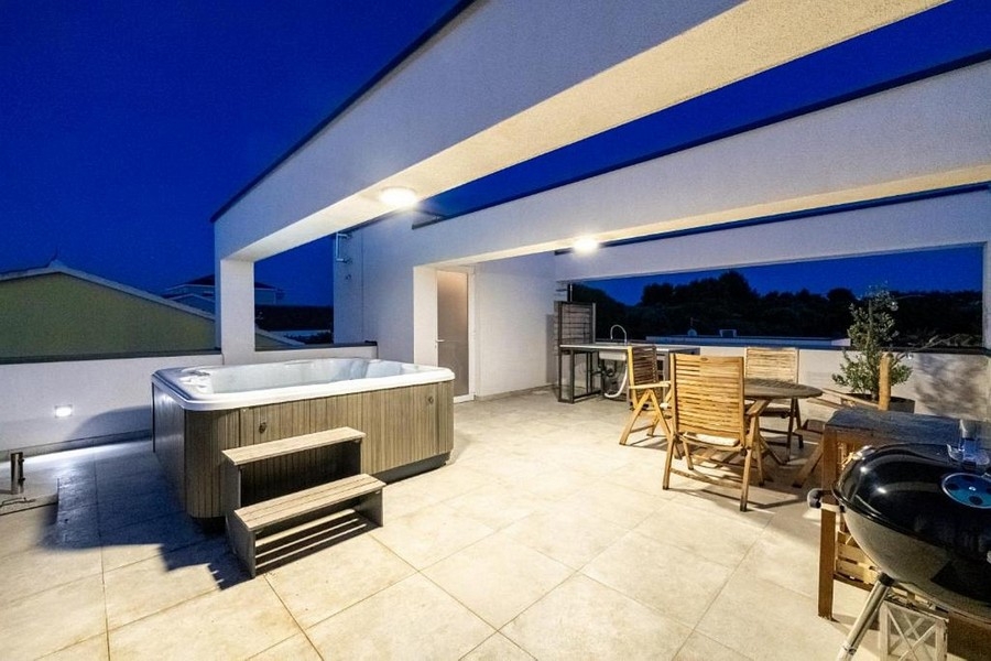 Terrazza sul tetto con idromassaggio e zona pranzo di sera