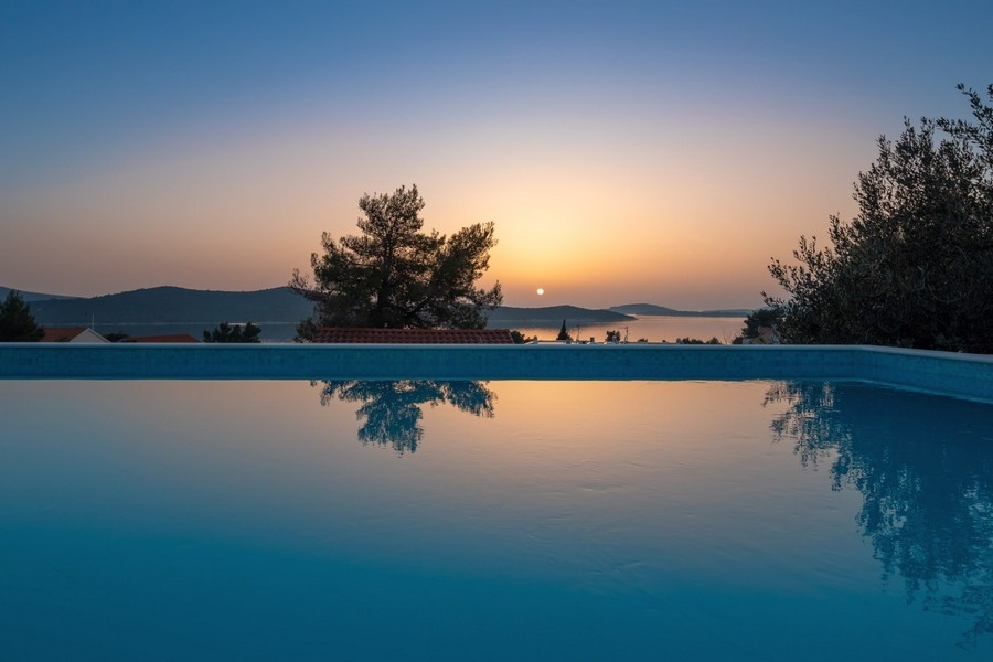 Piscina a sfioro al tramonto con vista panoramica sul mare