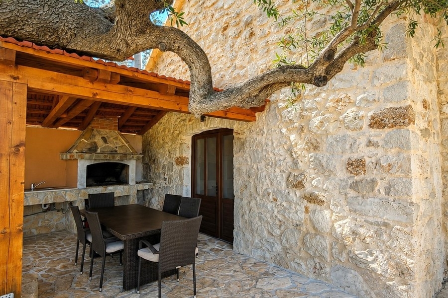 Zona salotto coperta con grill in pietra