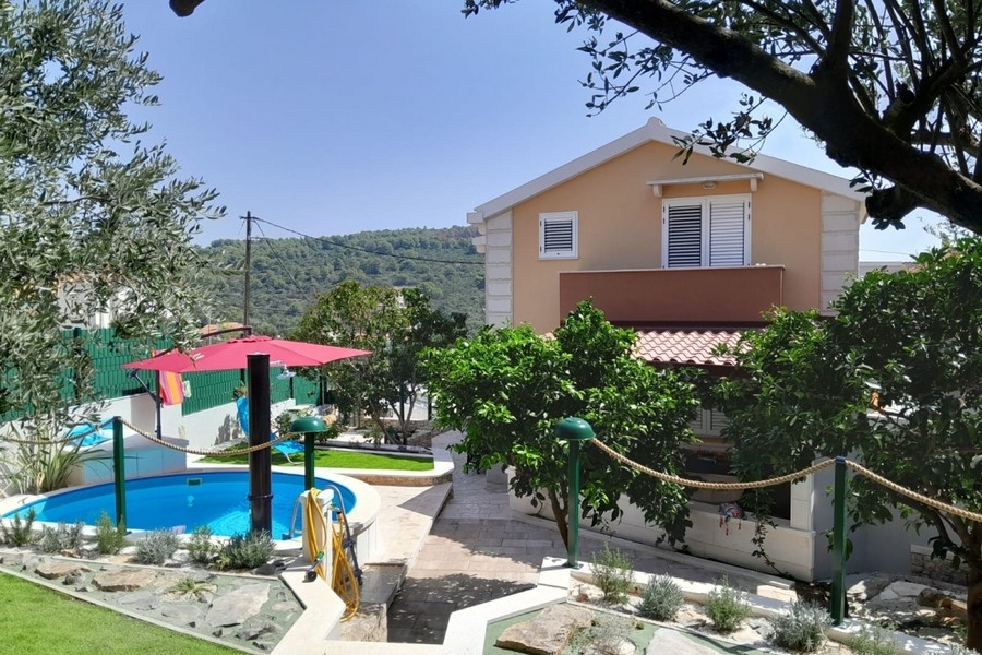 Vista esterna della casa con giardino e piscina
