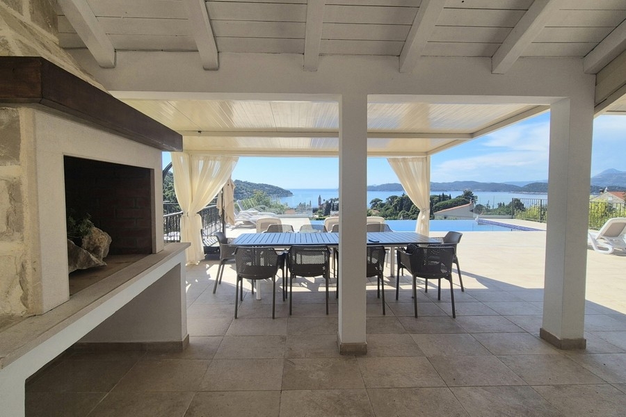 Terrazza coperta con camino e tavolo da pranzo