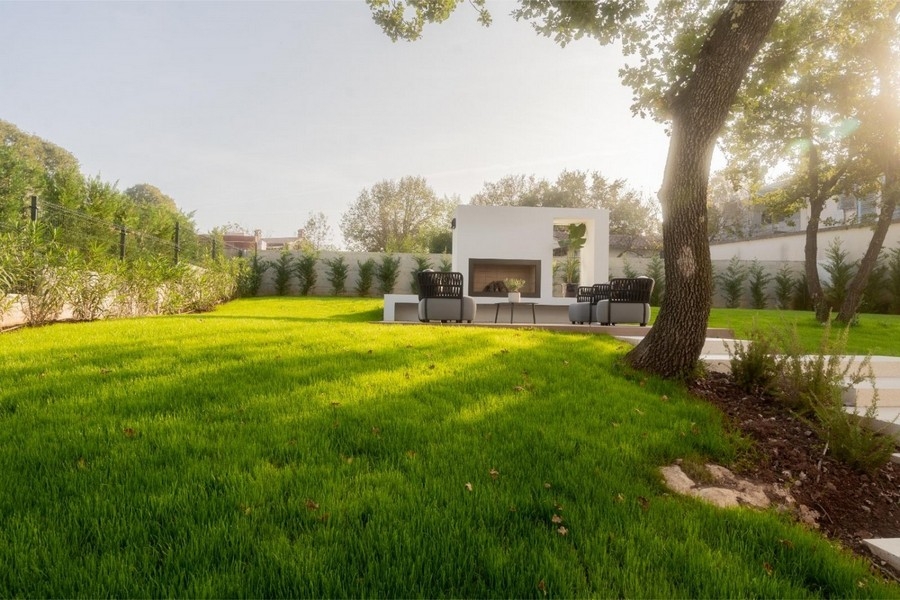 Giardino con camino esterno e poltrone lounge