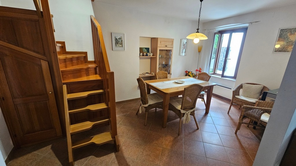 Zona giorno con tavolo e scala in legno