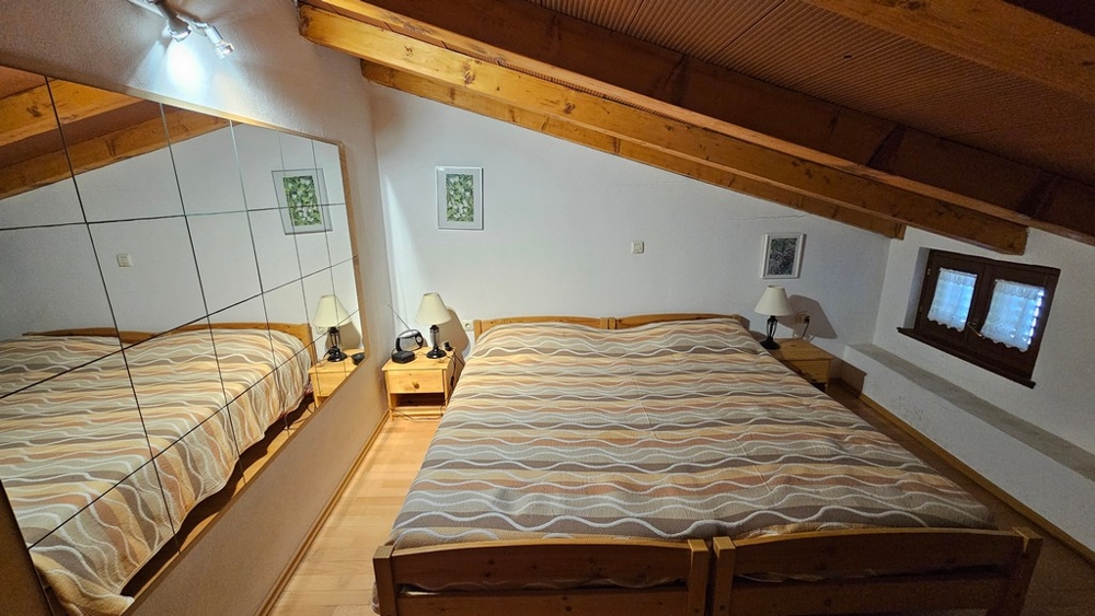Camera da letto nel sottotetto con letto matrimoniale