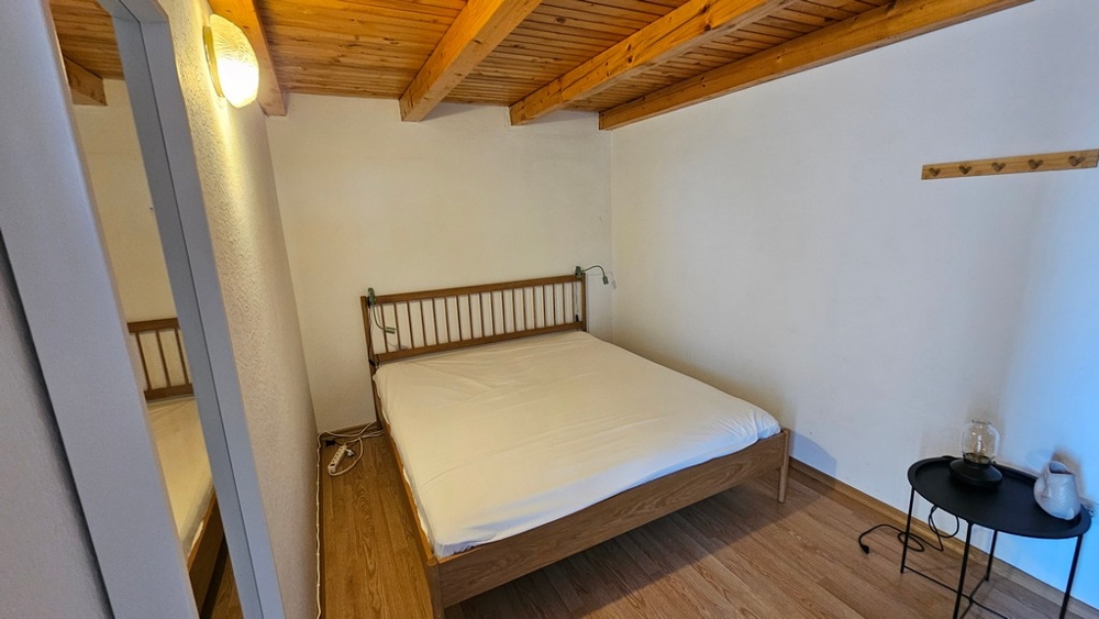 Camera da letto con letto matrimoniale e soffitto con travi in legno