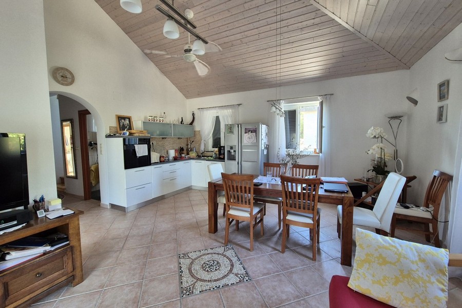 Zona giorno aperta con cucina e ventilatore a soffitto