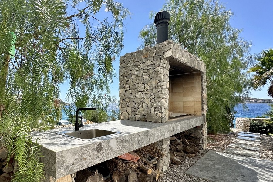 Camino esterno in muratura con grill e lavello sul mare