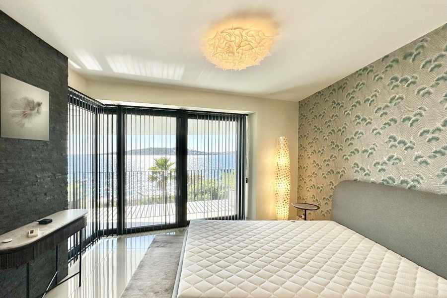 Camera da letto con vetrata ad angolo e vista mare