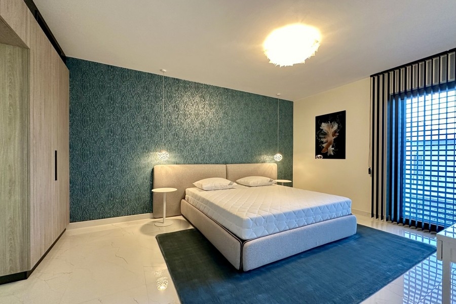Camera da letto con parete azzurra e letto matrimoniale