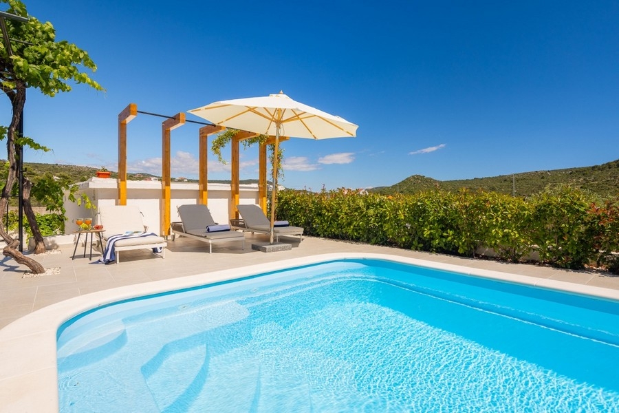 Piscina con lettini e pergola