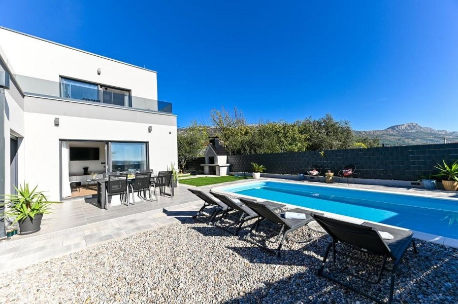 Area esterna con piscina e zona salotto coperta