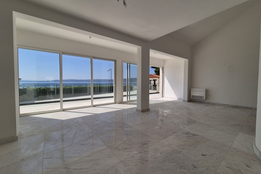 Zona giorno luminosa con vista mare e finestre a tutta altezza