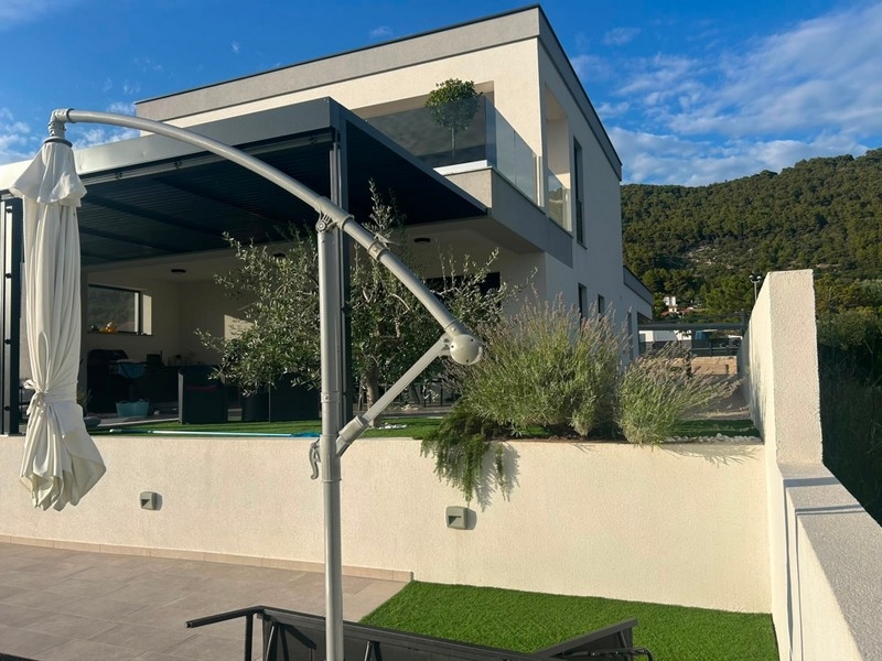 Terrazza coperta con ombrellone presso la casa di nuova costruzione su Rab