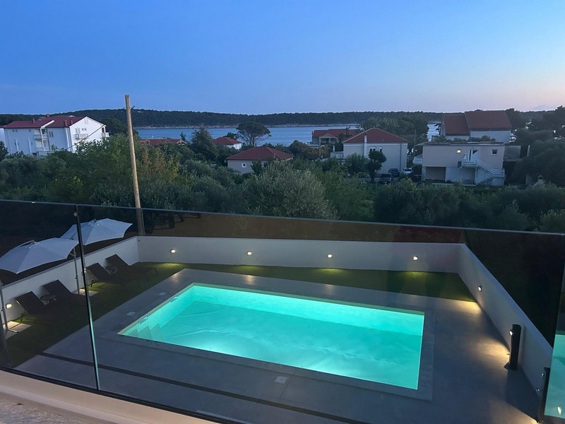 Piscina illuminata con vista su Banjol e sulla baia