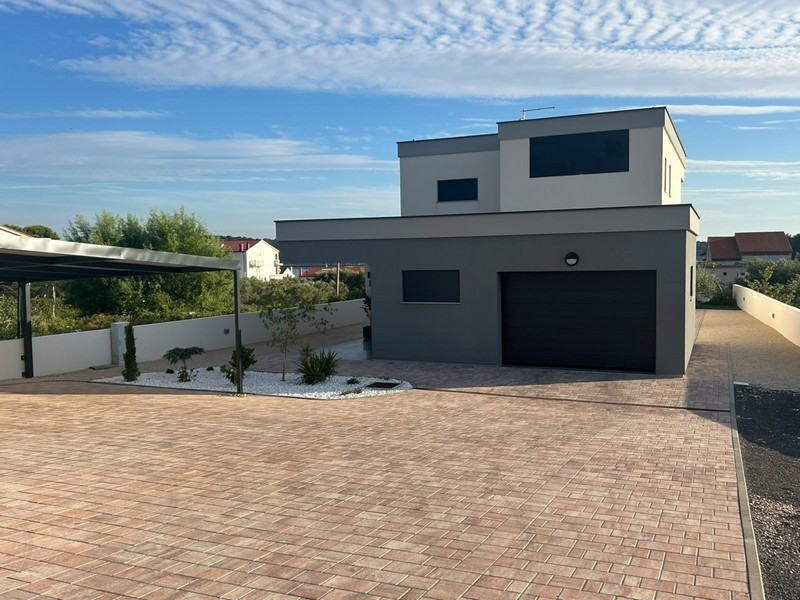 Vista della casa con garage e piazzale pavimentato