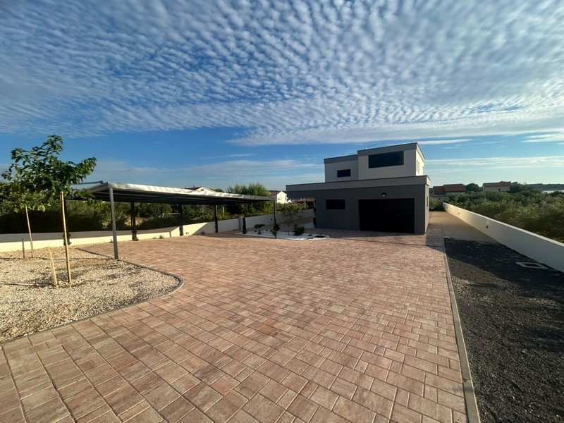 Piazzale con posto auto coperto e vista della casa