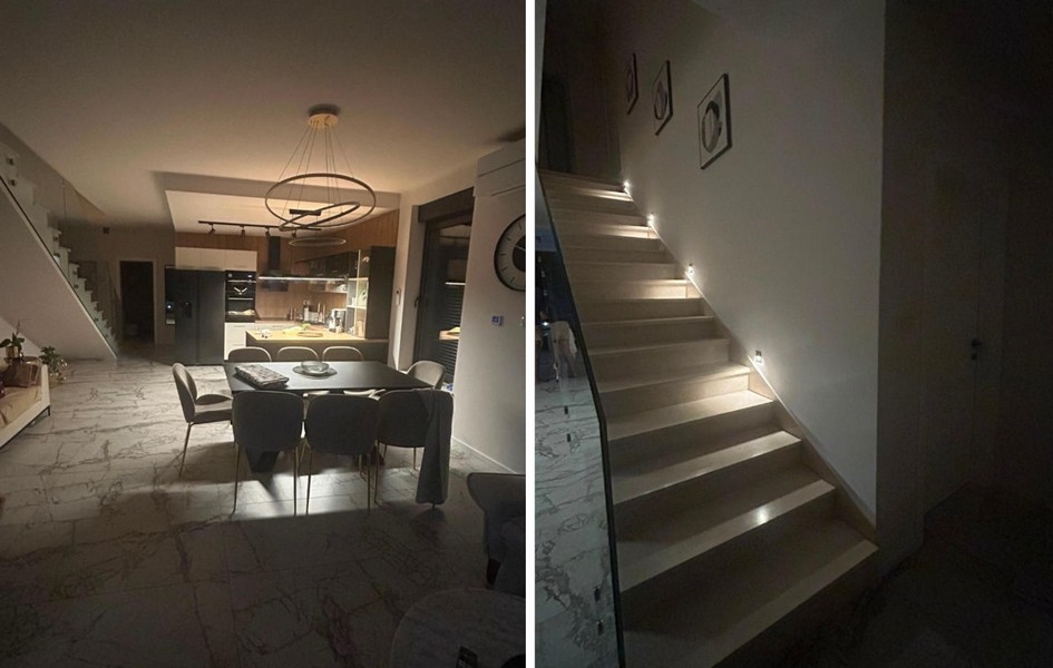 Zona giorno con cucina aperta e scala illuminata