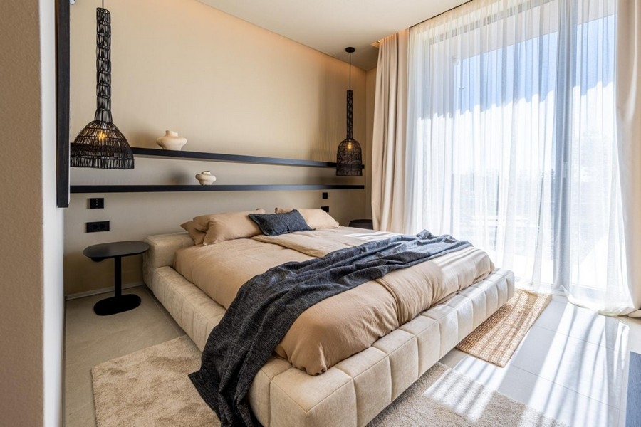 Camera da letto con letto matrimoniale e finestre a tutta altezza