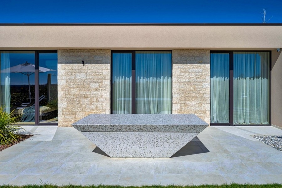 Terrazza con tavolo in pietra e vetrata della villa