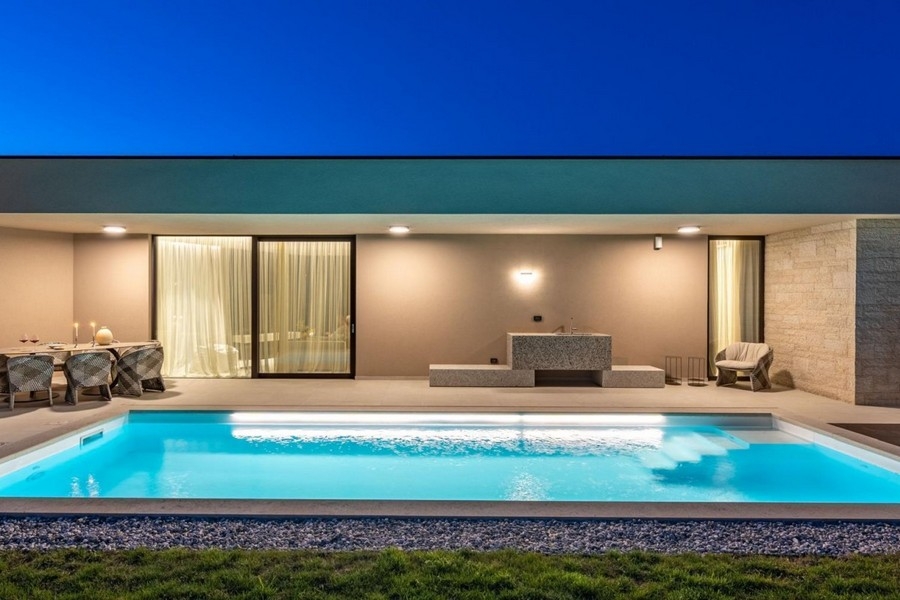 Piscina illuminata e terrazza della villa vicino a Porec la sera