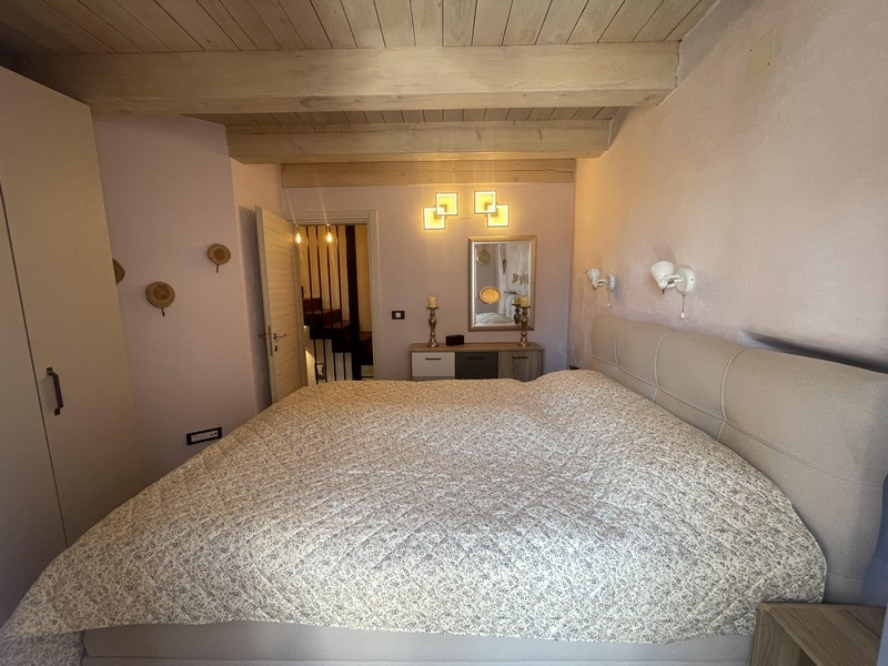 Camera da letto con letto matrimoniale e soffitto a travi di legno