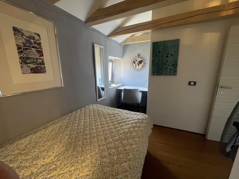 Camera da letto sotto il tetto con travi in legno