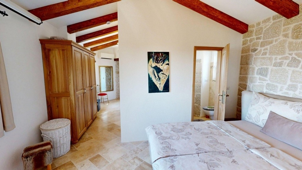 Camera da letto con soffitto a travi di legno al piano superiore