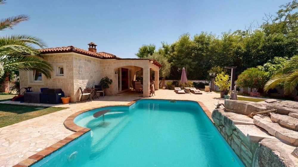 Piscina con solarium e vista sulla casa