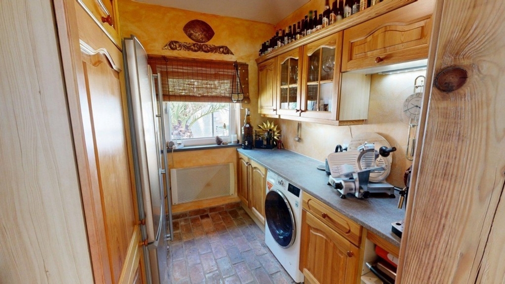 Blocco cucina con armadi in legno e lavatrice