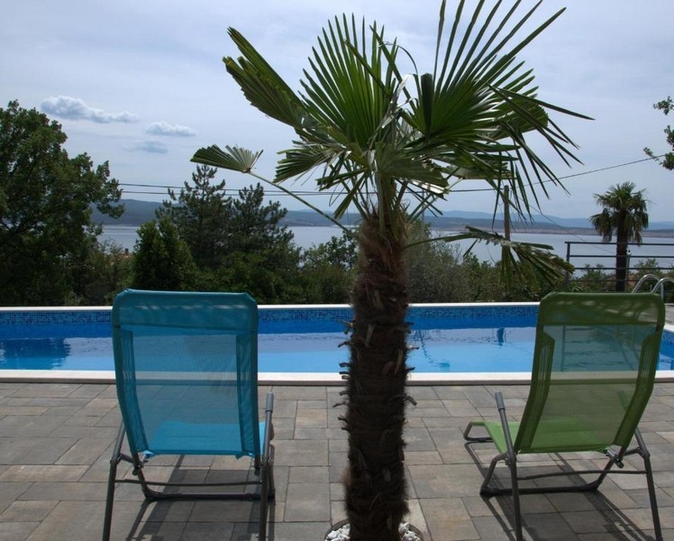Piscina con lettini e palma a Crikvenica