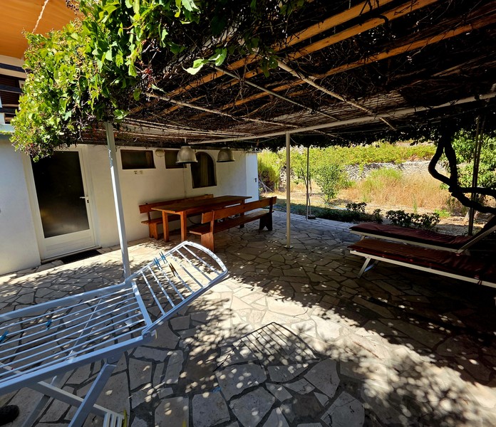 Terrazza ombreggiata con pavimento in pietra naturale davanti alla casa