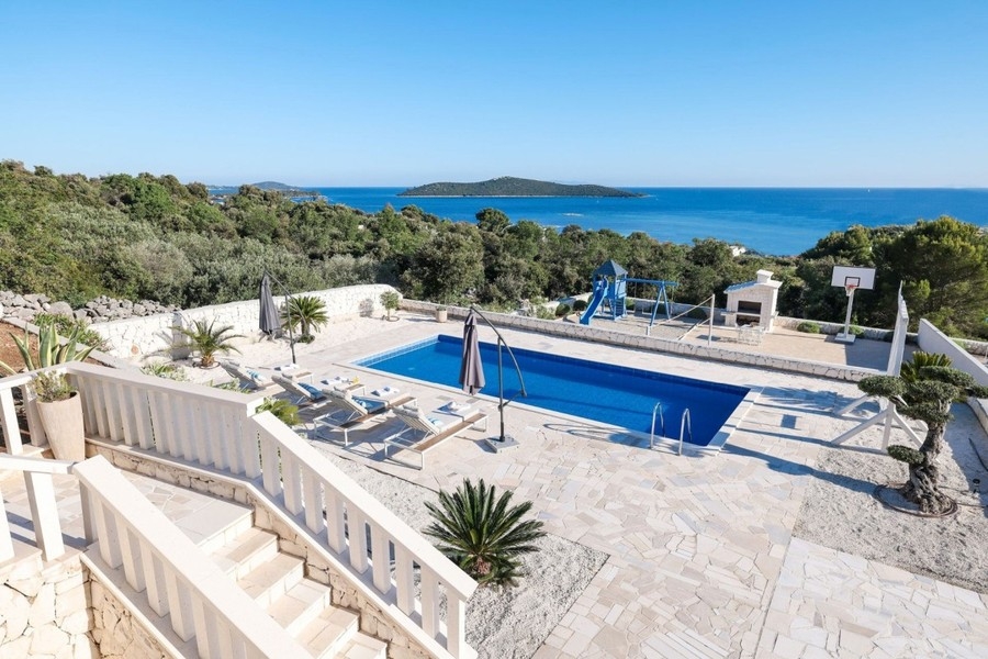 Piscina con lettini e vista sul mare