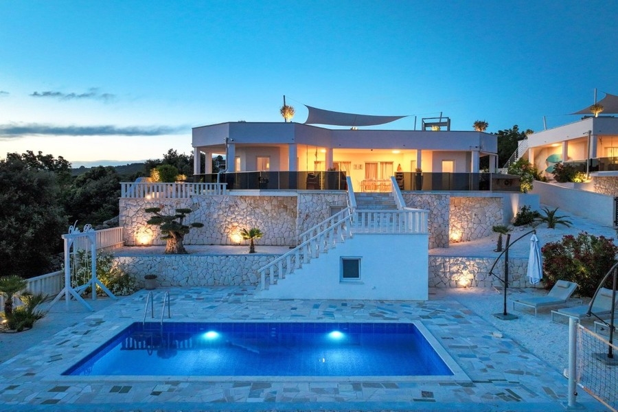 Proprietà la sera con piscina illuminata