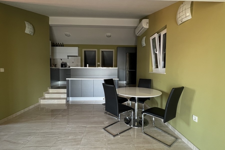 Cucina abitabile aperta con tavolo e climatizzazione