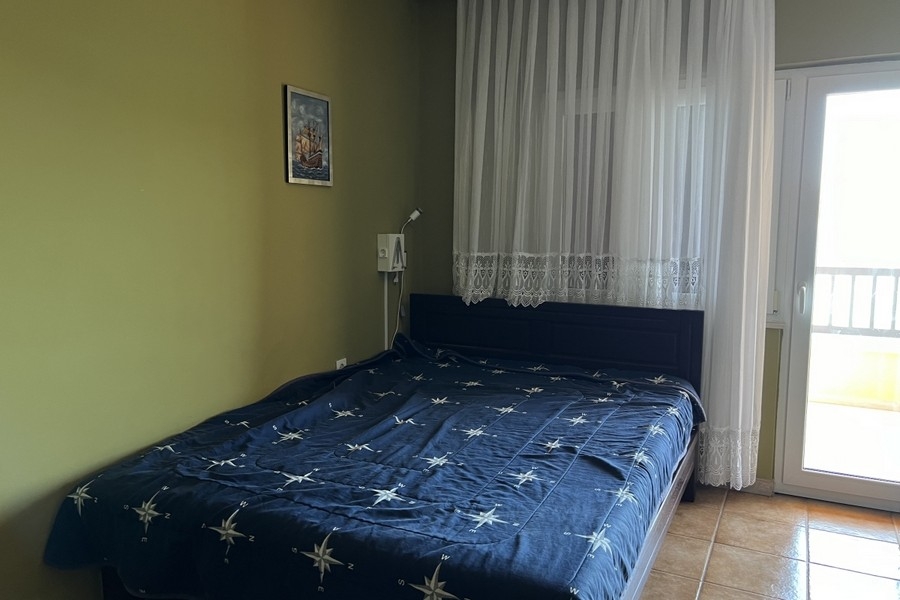 Camera da letto con letto matrimoniale e porta del balcone