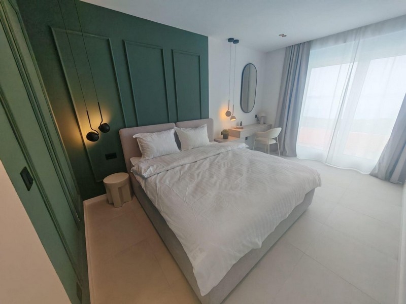 Camera da letto con rivestimento verde alle pareti