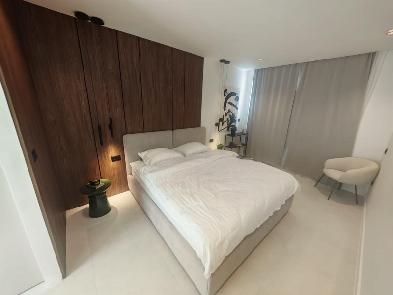 Camera da letto con parete in legno e letto matrimoniale