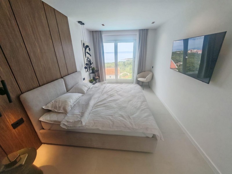 Camera da letto con porta del balcone e vista sulla natura