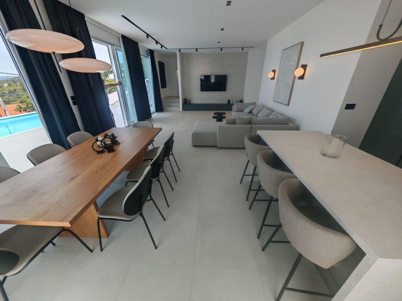 Zona giorno aperta con tavolo da pranzo e isola cucina