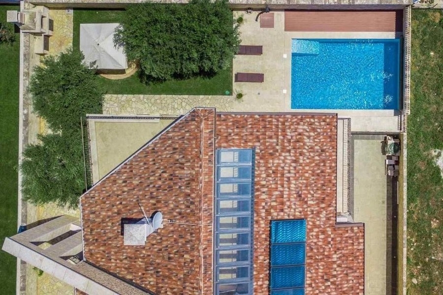 Veduta aerea di casa, giardino e piscina