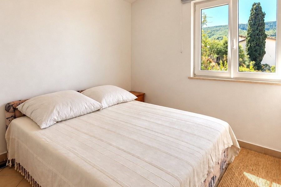 Camera da letto luminosa con letto matrimoniale e vista sul verde