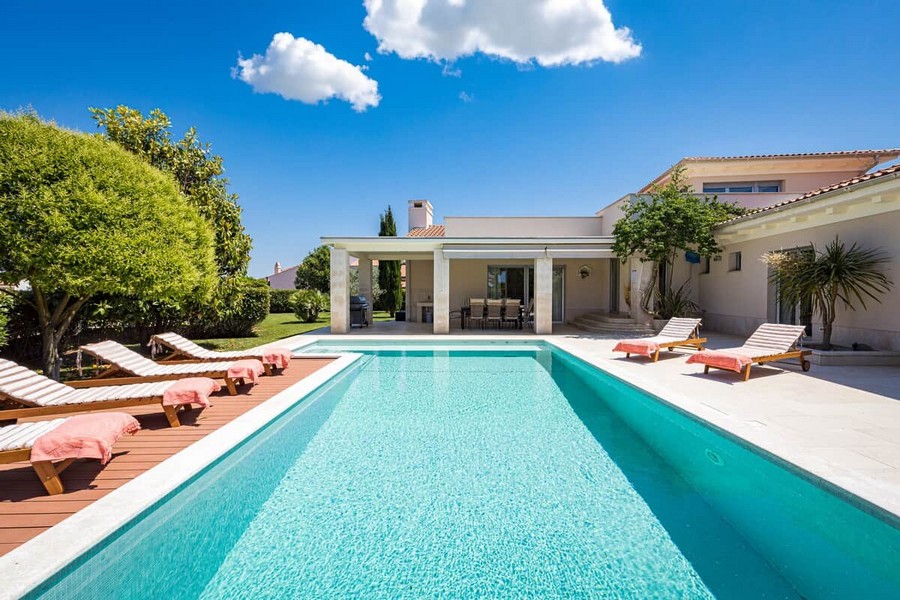 Piscina e solarium davanti alla villa