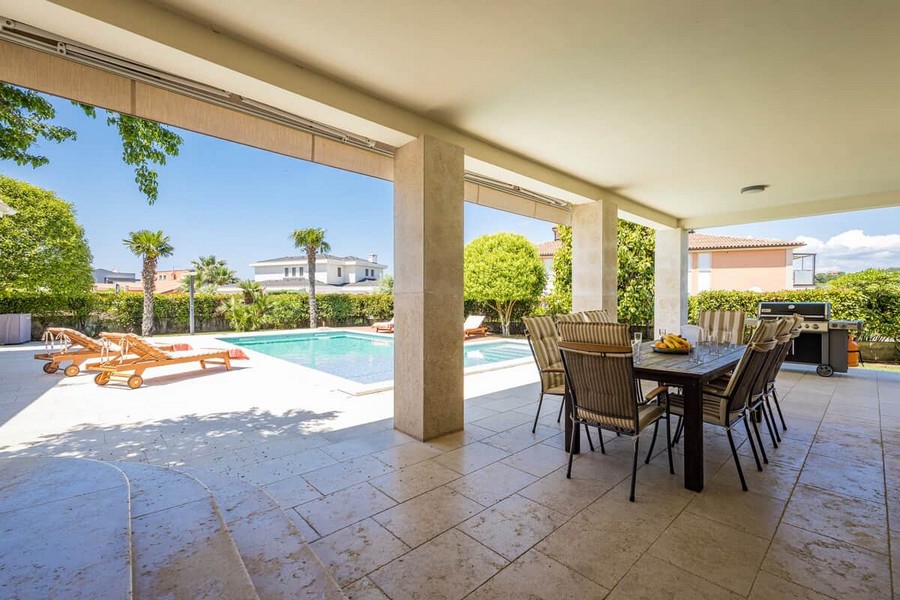Terrazza coperta con tavolo da pranzo presso la piscina