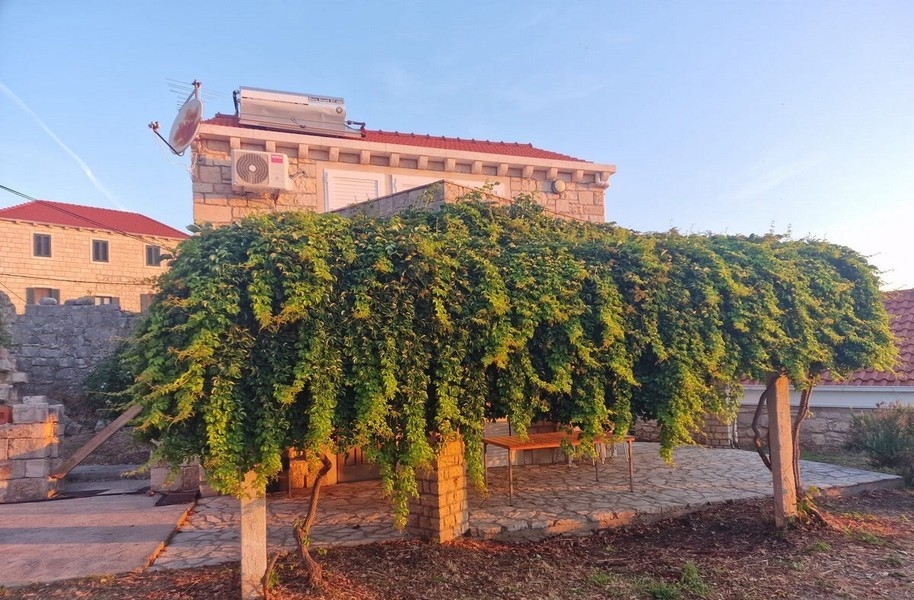 Casa in pietra con pergola verde e terrazza